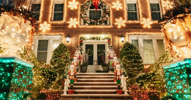 Guide leading visitors on a Dyker Heights Christmas lights NYC bus tour past a decorated Brooklyn house