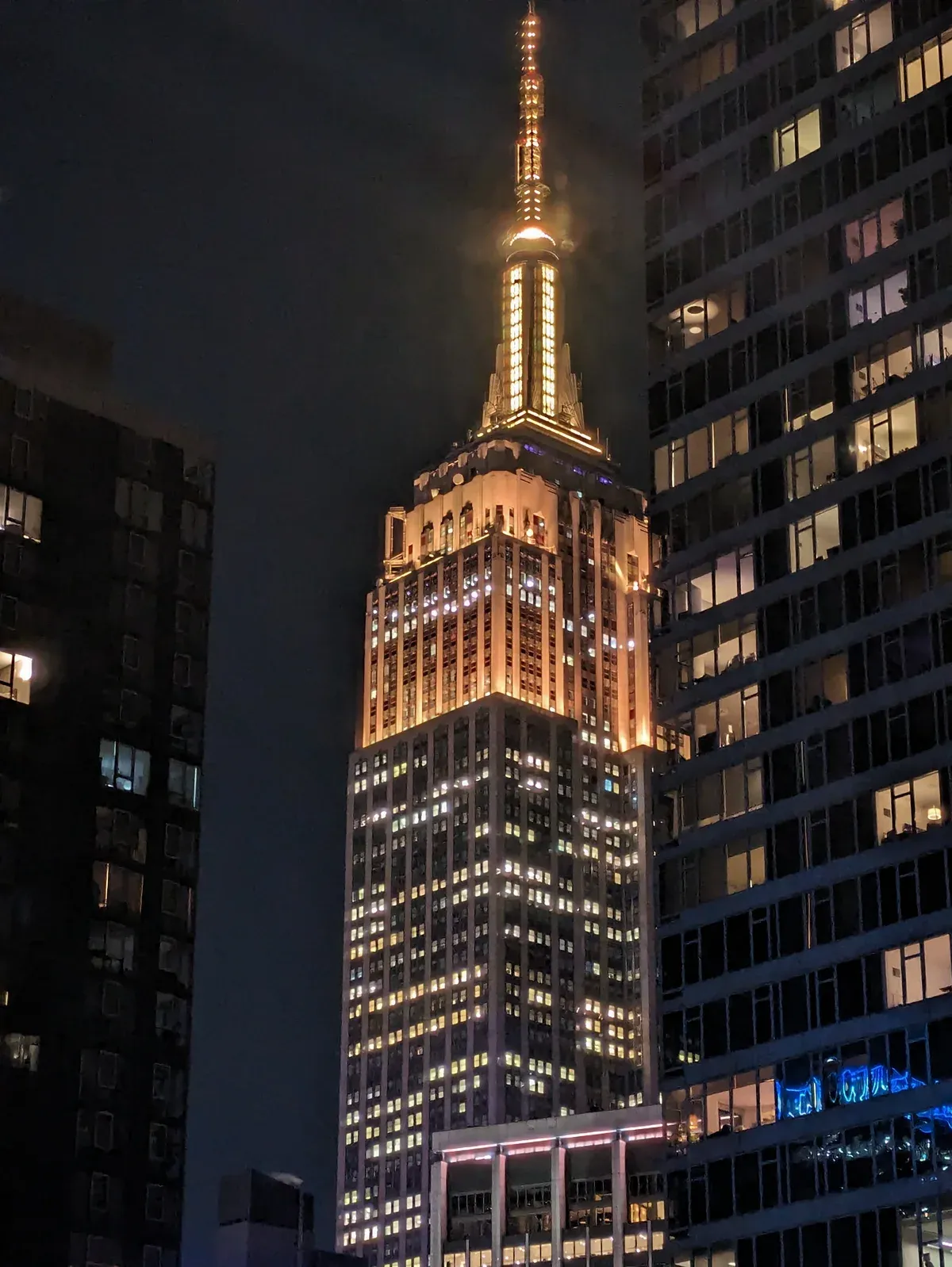 The Empire State Building lit at night above Midtown, a stop on the Big Bus New York Downtown loop