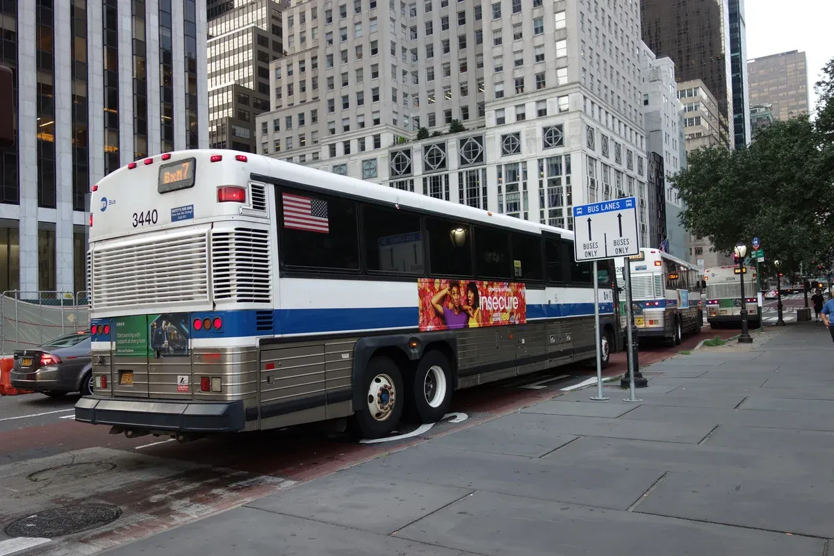 An MTA city bus in the Fifth Avenue bus lane at 59th Street, the cheap alternative to NYC bus tours