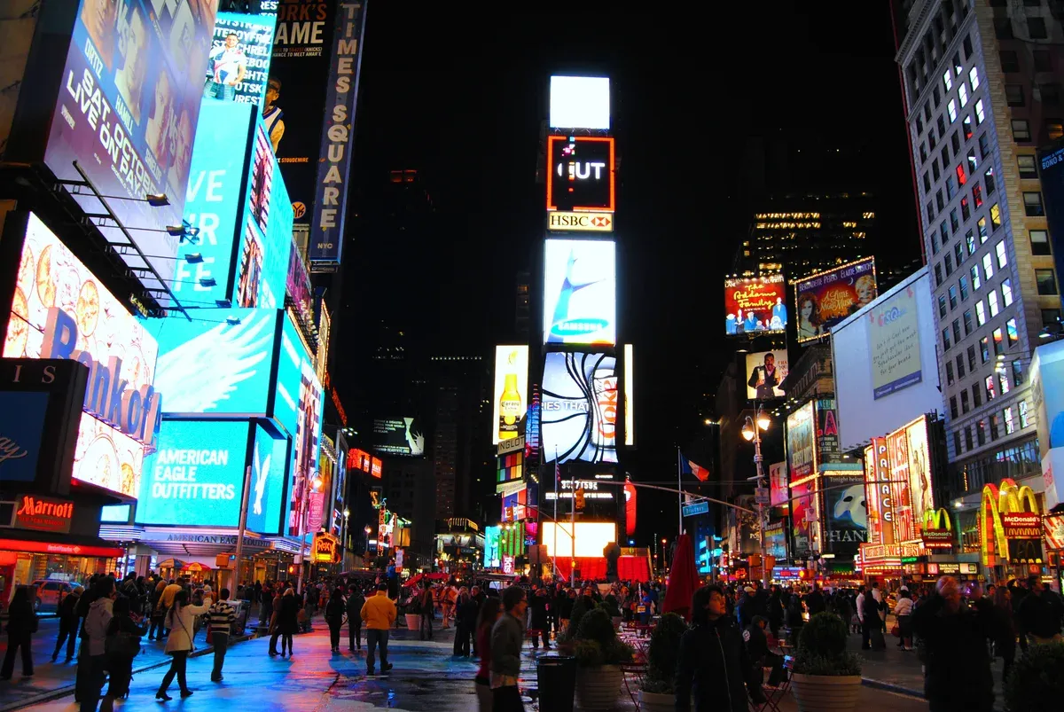 Times Square at night, where the NYC hop-on hop-off loops begin